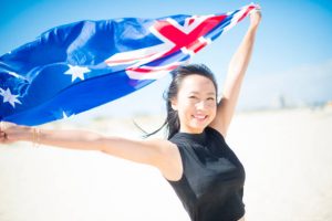 Beautiful young woman celebration citizenship with the Australian national flag on a beach, Perth Western Australia.